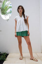 Load image into Gallery viewer, woman in the White Maya Embroidered Blouse paired in green shorts
