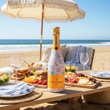 Load image into Gallery viewer, Champagne Bottle covered with the Pink Seashells Champagne Bottle Wrap on a table set on a beach
