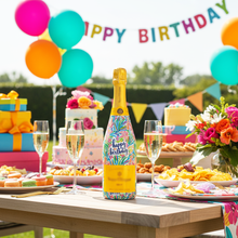 Load image into Gallery viewer, Champagne Bottle covered with the Happy Birthday Floral Bottle wrap on a table set for a birthday party
