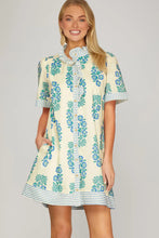 Load image into Gallery viewer, cream dress with blue flower print with short sleeve blue striped accents along the button down front sleeves and hem
