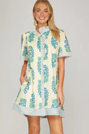 cream dress with blue flower print with short sleeve blue striped accents along the button down front sleeves and hem