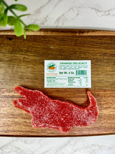 Load image into Gallery viewer, Florida Citrus Candy, Alligator Delicacy, Orange, 2oz on a cutting board
