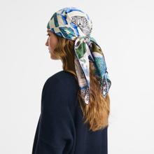 Load image into Gallery viewer, person wearing the Longchamp Jardin Parisien Silk scarf 90 around her head
