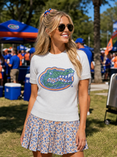 Load image into Gallery viewer, person wearing the University of Florida Gator Head Ivory Short Sleeve Sweater at a tailgate
