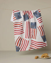 Load image into Gallery viewer, Towel hung up on a line, white/cream with a the American flag made from floral red and blue print 
