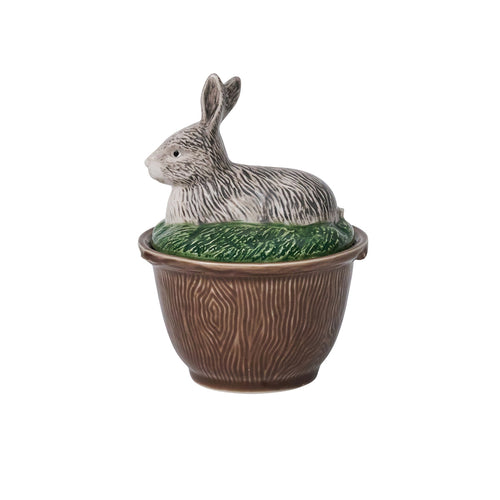 Brown bowl with a woodgrain texture and a lid shaped like a rabbit sitting in the grass