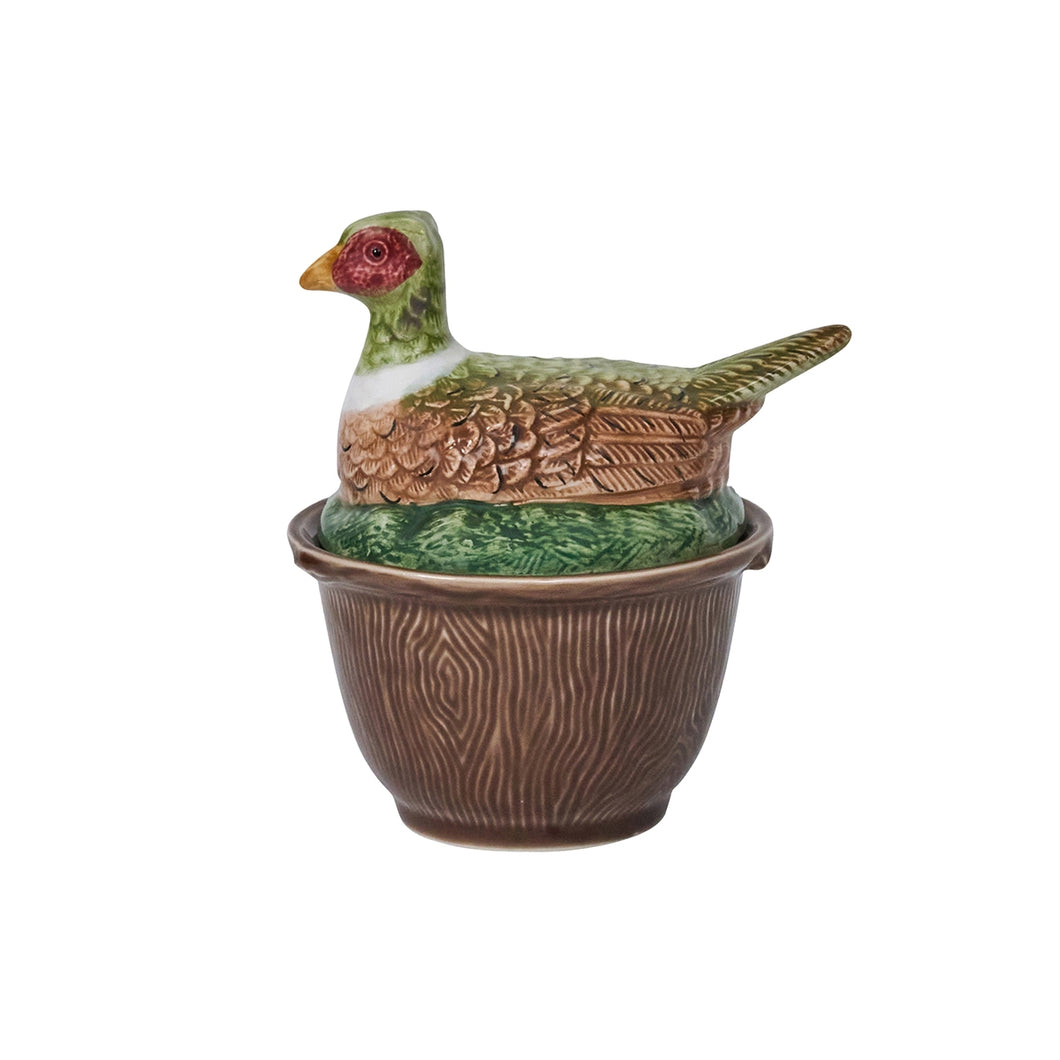 Brown bowl with a woodgrain texture and a lid shaped like a chicken sitting in the grass