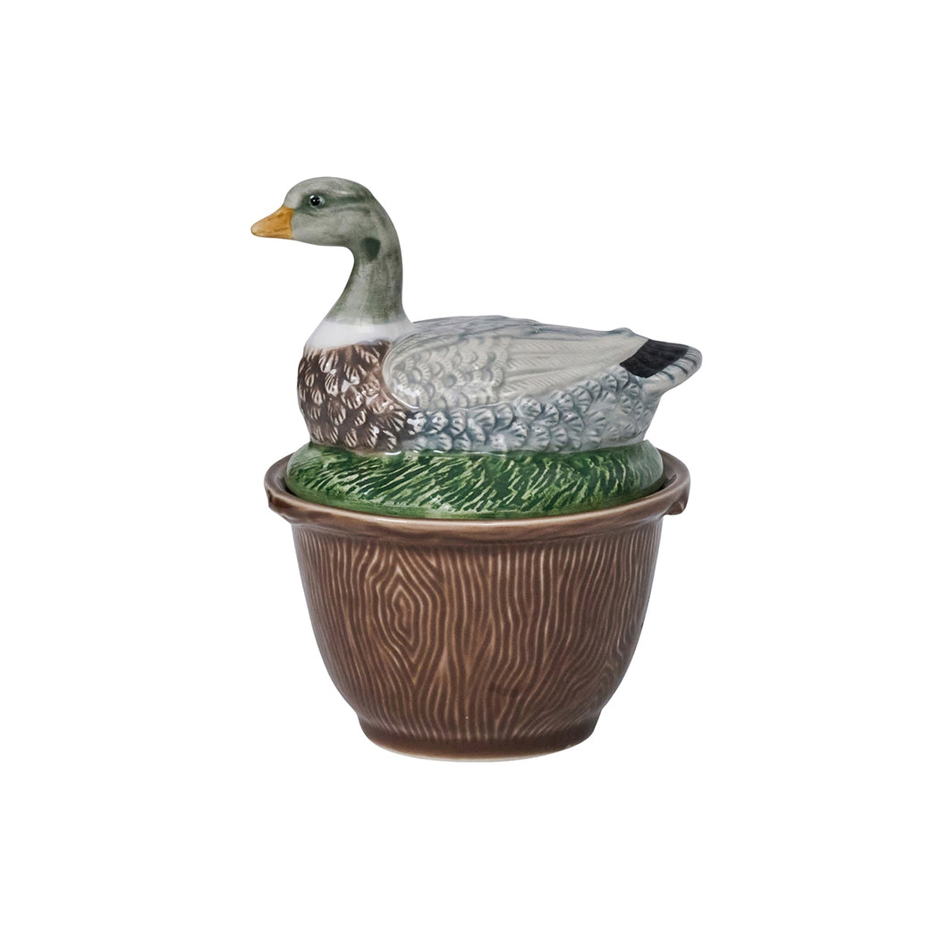 Brown bowl with a woodgrain texture and a lid shaped like a duck sitting in the grass