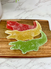 Load image into Gallery viewer, green gummy candy in three flavors red yellow and green on a cutting board
