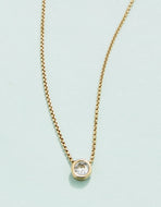 thin gold chain with solitaire stone at the center 