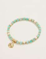 white and sea foam blue stone interspersed with gold beads with a single sand dollar charm