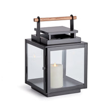 Load image into Gallery viewer, black metal lantern with glass sides and wood handle on the top of the lantern

