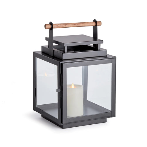 black metal lantern with glass sides and wood handle on the top of the lantern