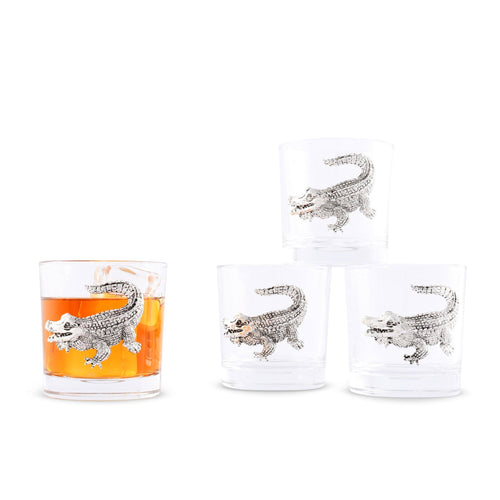 Four short glass with silver-colored alligator design one glass willed with an amber drink