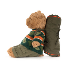 Load image into Gallery viewer, Stuffed teddy bear wearing a striped sweater and backpack on a white background side view
