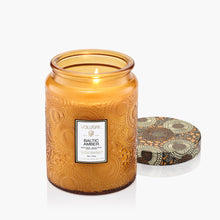 Load image into Gallery viewer, Voluspa Baltic Amber Large Jar Candle lit with the lid next to it
