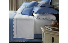 Load image into Gallery viewer, Matouk Butterfield bed linen in what and a dark blue paired with blue accent pillows
