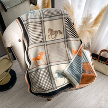 Load image into Gallery viewer, Patchwork blanket with horse designs draped over a chair in a room.
