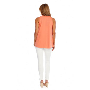 woman in an orange sleeveless shirt and white pants photographed from the back
