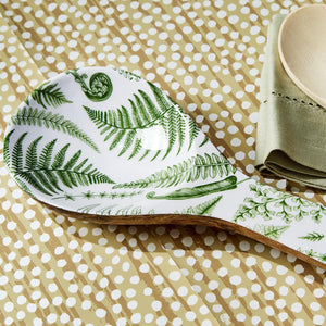 Close up of wood spoon rest with white and green pattern