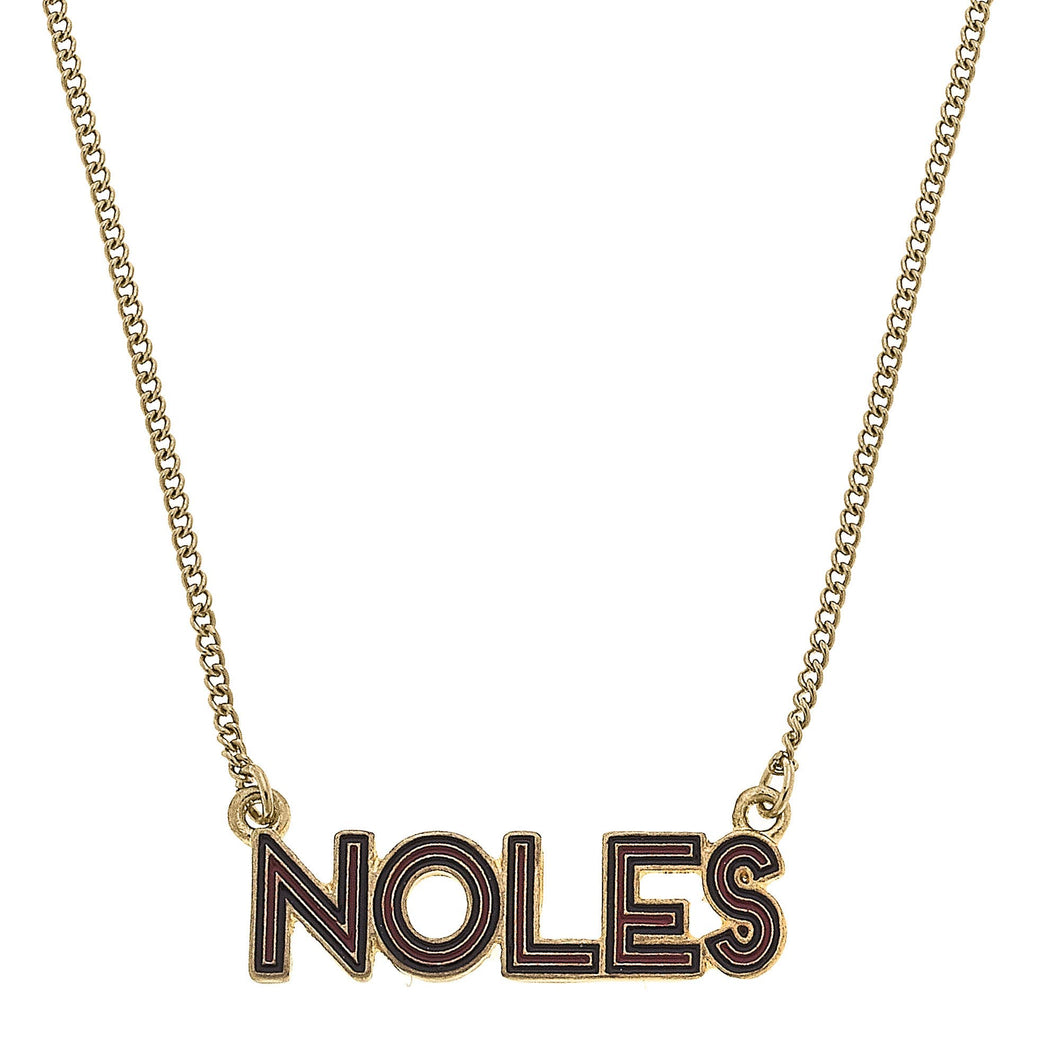 Close up of pendant on a gold necklace - Pendant reads NOLES with maroon and black enamel 