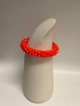Load image into Gallery viewer, Red beaded bracelet on a white cylindrical object against a neutral background

