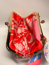 Load image into Gallery viewer, Open handbag with red and pink floral pattern on a light background
