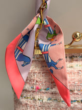 Load image into Gallery viewer, Colorful scarf with abstract designs on a gold hook against a textured wall.
