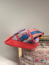 Load image into Gallery viewer, Colorful geometric-patterned scarf draped over a textured surface with a neutral background
