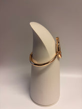 Load image into Gallery viewer, Gold bracelet on a white cylindrical stand against a gray background
