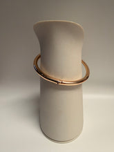 Load image into Gallery viewer, Beige cylindrical object with a gold ring on a gray background
