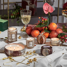 Load image into Gallery viewer, many Voluspa Gilt Pomander Hinoki  Candles on a table set with golden decorations and fruit 
