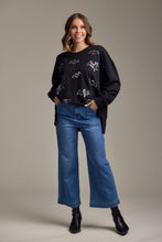 Load image into Gallery viewer, person wearing Jake Wide Leg Pants, wide leg blue jeans with black shirt printed with bats and black boots

