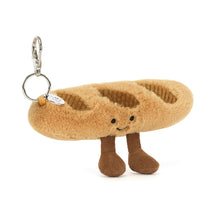 Load image into Gallery viewer, front view of the Jellycat Amuseables Baguette Bag Charm showing the metal hook, a smiling face and little legs
