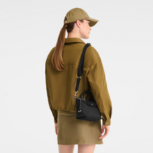 Load image into Gallery viewer, person holding Longchamp Le Pliage Energy X-Small Top Handle Bag in black 
