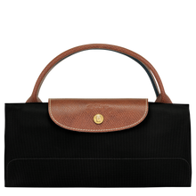 Load image into Gallery viewer, person holding the Longchamp Le Pliage Original X-Large Travel Bag in black folded and snapped closed
