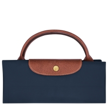 Load image into Gallery viewer, person holding the Longchamp Le Pliage Original X-Large Travel Bag in navy folded and snapped closed
