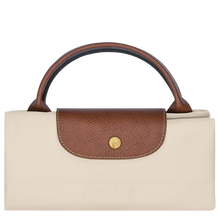 Load image into Gallery viewer, person holding the Longchamp Le Pliage Original X-Large Travel Bag in paper folded and snapped closed
