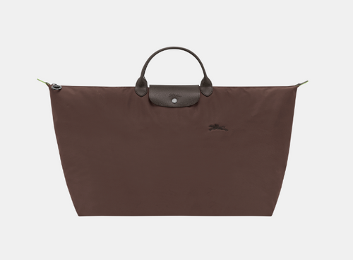 brown canvas tote with leather flap and leather handles above the strap 