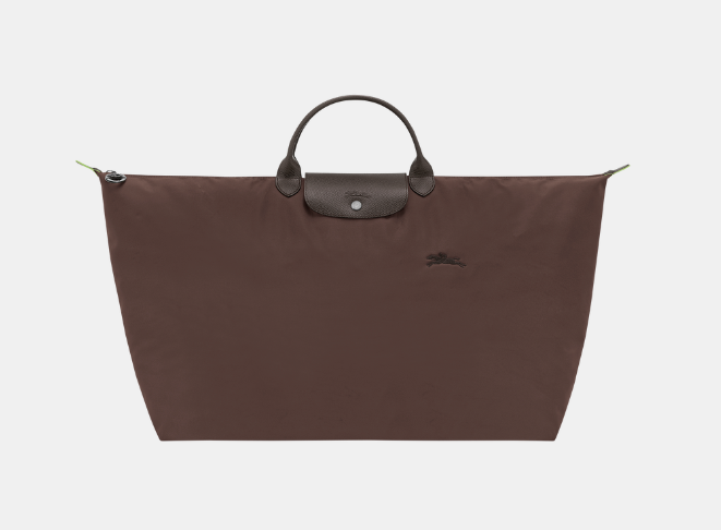 brown canvas tote with leather flap and leather handles above the strap 