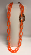 Orange chain necklace on a mannequin bust against a white background