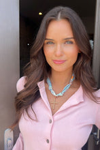 Load image into Gallery viewer, woman wearing a pastel fabric necklace with gold cross pendant 
