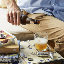 Load image into Gallery viewer, person pouring a beer with the bottle opener next to the glass
