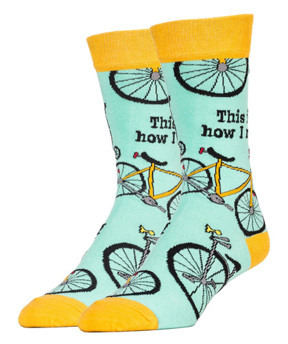 Light blue and orange socks with images of bicycles and the text This is how I ride