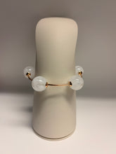 Load image into Gallery viewer, Pair of earrings with white spherical beads on a beige stand against a neutral background
