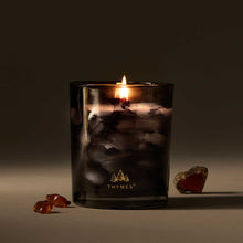 Load image into Gallery viewer, Frosted Black candle holder with lit candles sitting next to amber shards 
