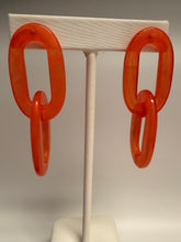 Load image into Gallery viewer, Red plastic chain on a white stand against a plain background

