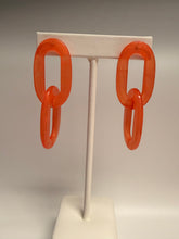 Load image into Gallery viewer, Two orange chain links on a white stick against a gray background
