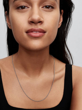 Load image into Gallery viewer, Woman wearing a silver necklace against a neutral background
