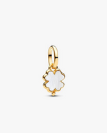 Gold pendant with a white enameled clover design on a light beige background